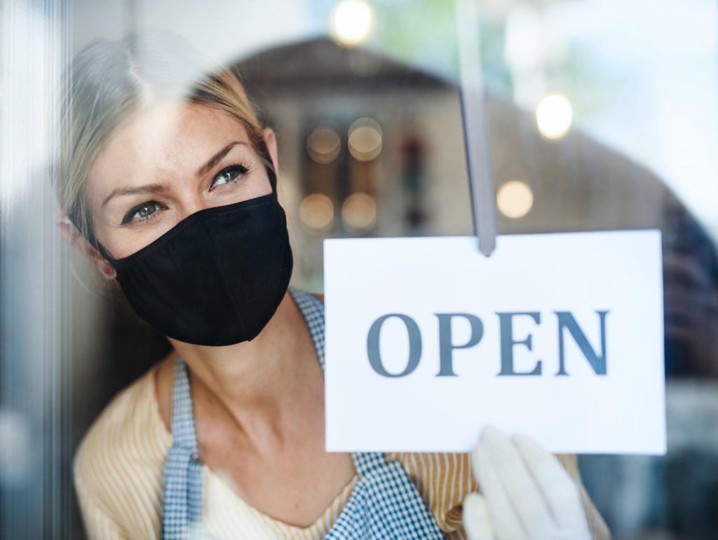 Woman in open shop window with mask